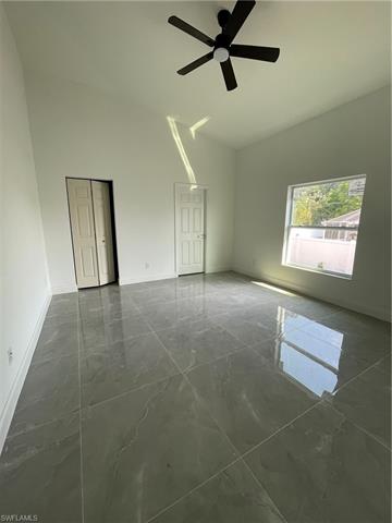 master bedroom with a ceiling fan, baseboards, marble finish floor, and high vaulted ceiling
