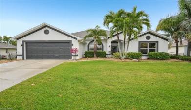 Single story home with stucco siding, a front yard, a garage, and driveway