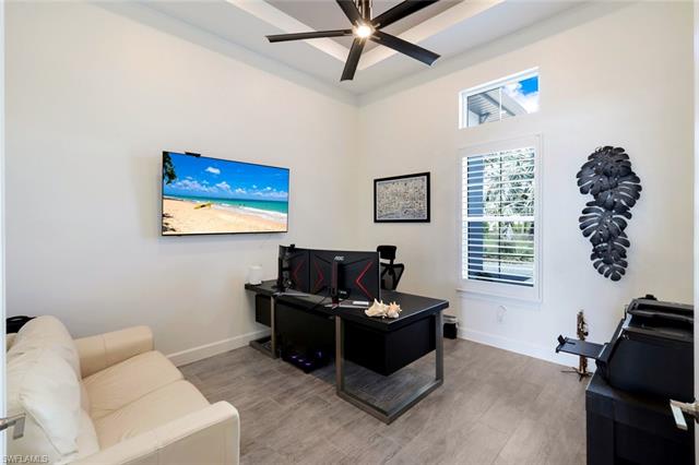 Office space with a ceiling fan, wood finished floors, and baseboards