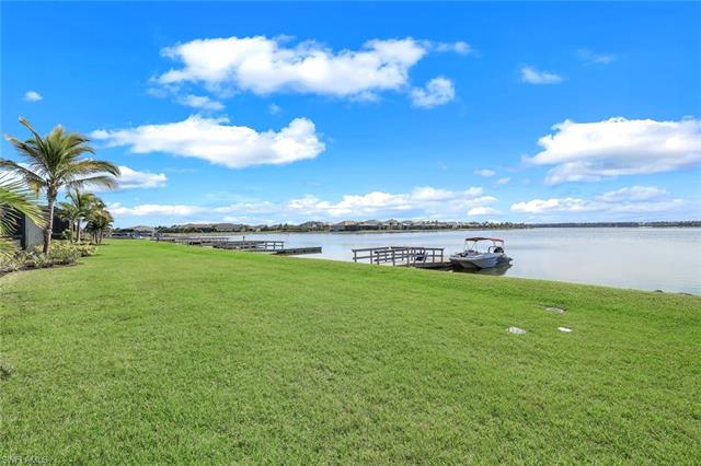 View of dock featuring a lawn and a water view