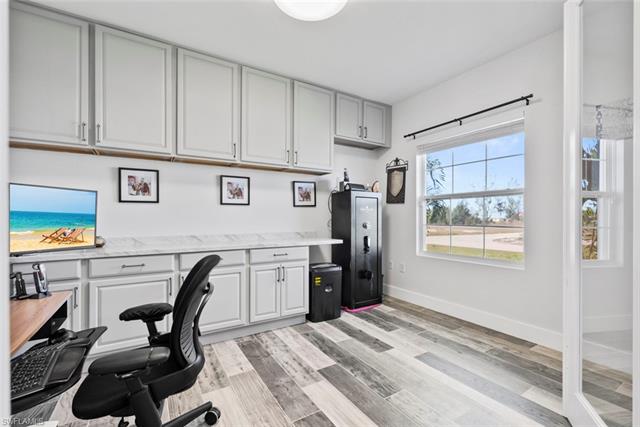 Home office featuring baseboards, light wood-style floors, built in study area, and fully soundproofed.