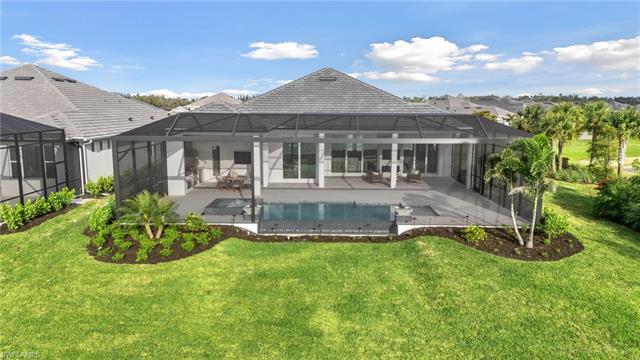 Back of property featuring a lanai, a lawn, a patio, and stucco siding