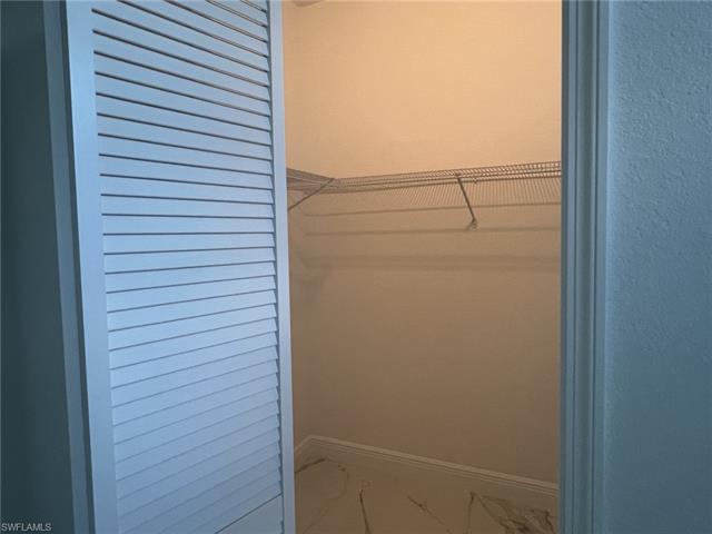 Walk in closet featuring marble finish floor