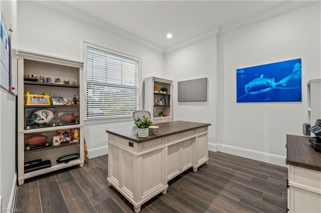 Office space with crown molding, and dark wood tile flooring.