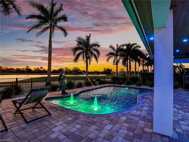 Pool at dusk with a patio area and fence