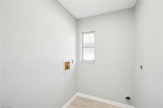 Washroom featuring hookup for a washing machine, baseboards, hookup for an electric dryer, laundry area, and light wood-style floors