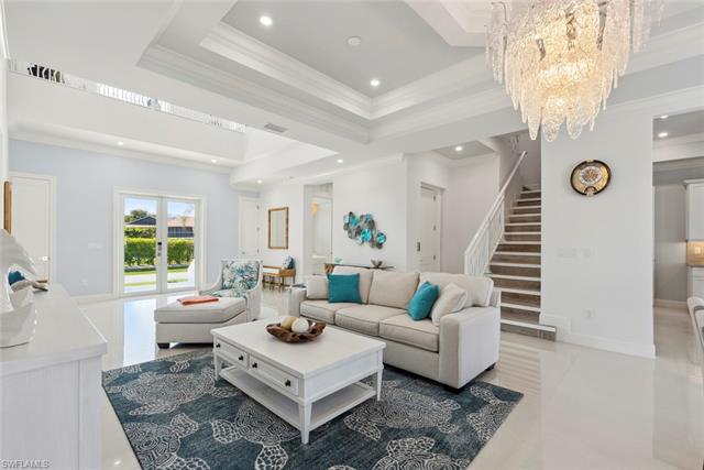 Living area featuring crown molding, stairway, recessed lighting, an inviting chandelier, and a raised ceiling