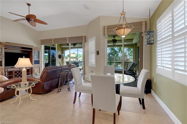 Dining space featuring light tile patterned floors, baseboards, lofted ceiling, and a ceiling fan