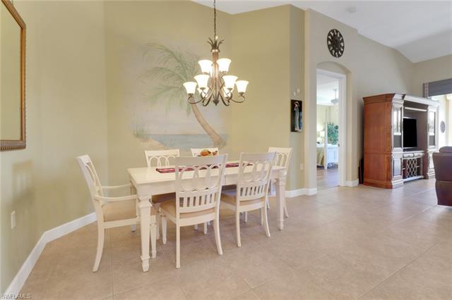 Dining area with baseboards, a notable chandelier, and light tile patterned flooring