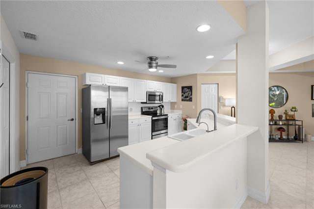 Kitchen with visible vents, a sink, appliances with stainless steel finishes, light countertops, and ceiling fan