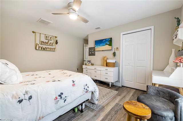 Bedroom with visible vents, wood finished floors, and a ceiling fan