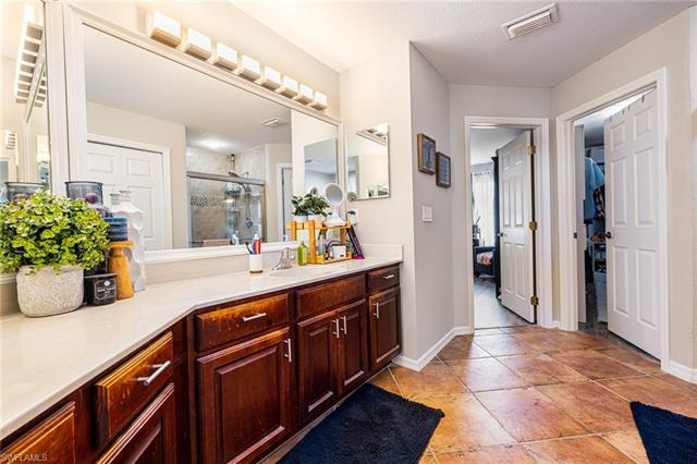 Bathroom with visible vents, a stall shower, vanity, and baseboards