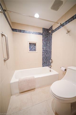 Bathroom featuring tile patterned floors, visible vents, tub / shower combination, and toilet