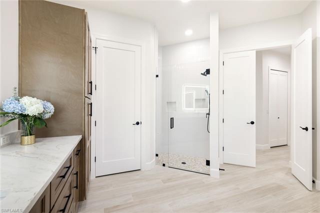 Full bathroom with recessed lighting, vanity, wood finished floors, and a shower stall