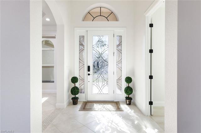 Plank Tiled entryway with tall baseboards and arched walkways