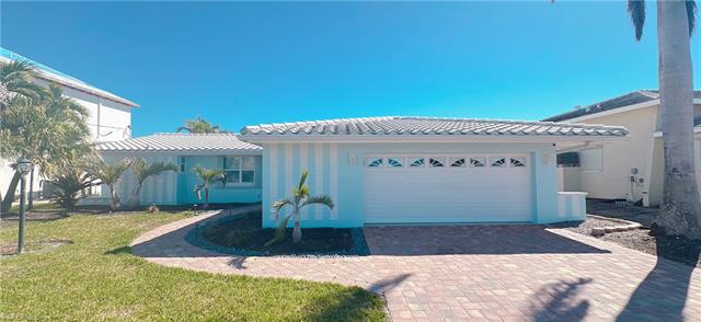 View of front of house featuring stucco siding, a tile roof, decorative driveway, a front yard, and a garage