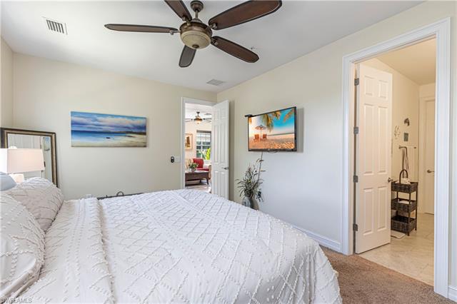 Carpeted bedroom featuring a ceiling fan, visible vents, and baseboards