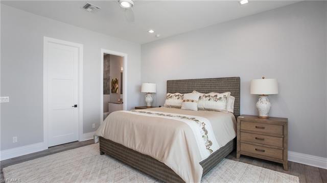 Bedroom with ceiling fan, wood finished floors, visible vents, and baseboards