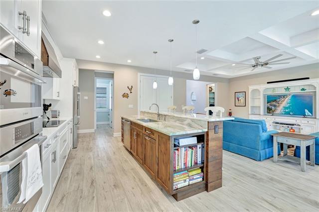 Kitchen with light wood-type flooring, a sink, recessed lighting, white cabinets, and brown cabinetry