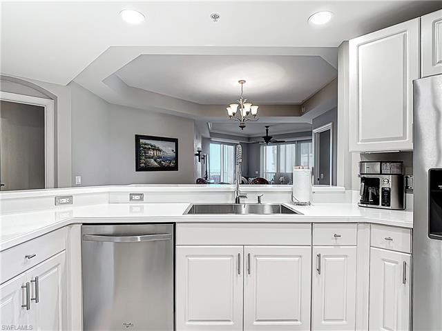 Kitchen with a notable chandelier, appliances with stainless steel finishes, white cabinetry, and a sink