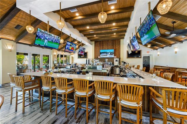 Bar featuring wooden ceiling, wood finished floors, a community bar, visible vents, and beamed ceiling