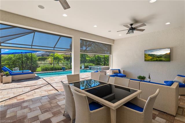 View of patio with a pool with connected hot tub, a lanai, and ceiling fan