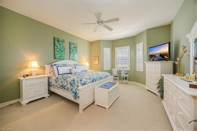 Bedroom with light colored carpet, baseboards, and a ceiling fan
