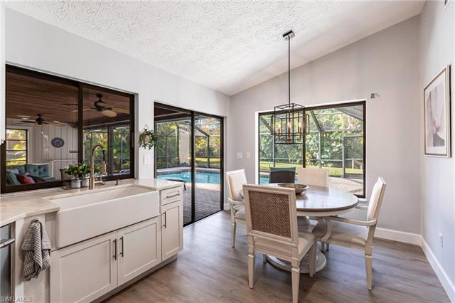 Dining space featuring ceiling fan, a sunroom, vaulted ceiling, and wood finished floors
