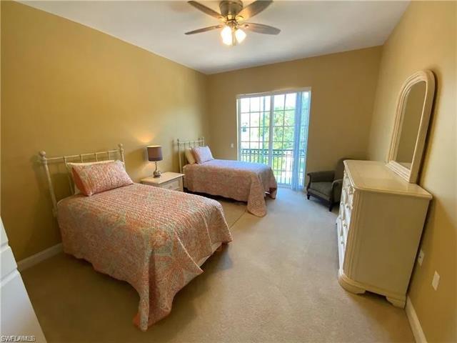 Bedroom with baseboards, access to exterior, a ceiling fan, and light carpet