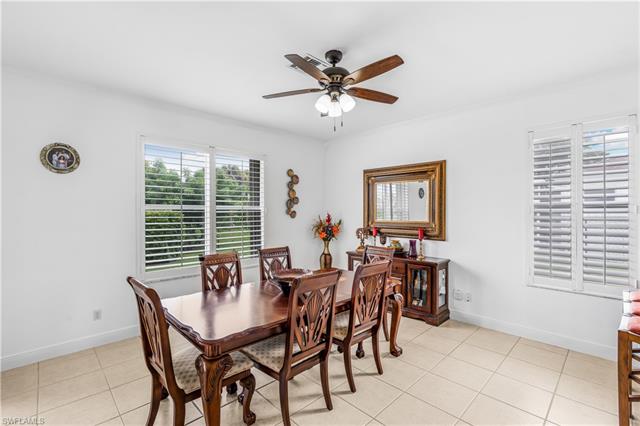 Dining space featuring light tile patterned floors, ornamental molding, baseboards, and a ceiling fan