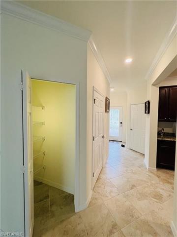 Corridor with baseboards and crown molding