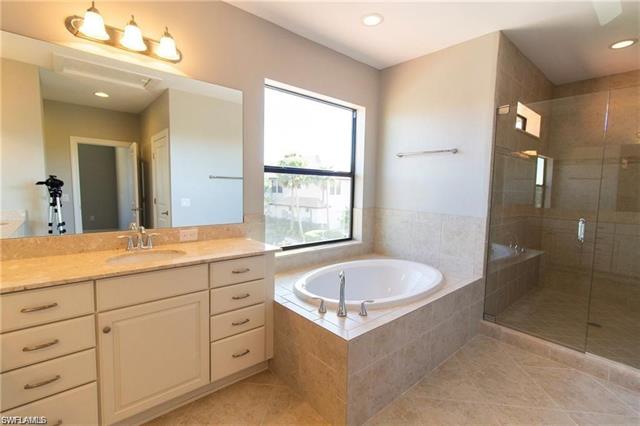Bathroom with a bath, a shower stall, tile patterned floors, recessed lighting, and vanity