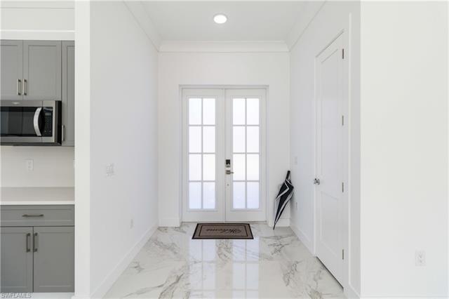 Entryway with french doors, marble finish floor, baseboards, ornamental molding, and recessed lighting