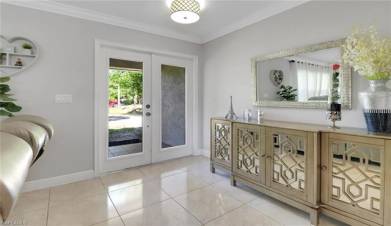 Foyer entrance featuring baseboards, ornamental molding, french doors, and tile patterned flooring