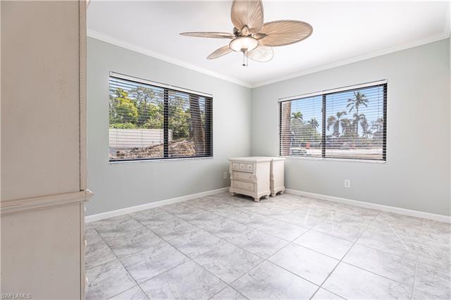 Unfurnished room featuring plenty of natural light, crown molding, and baseboards