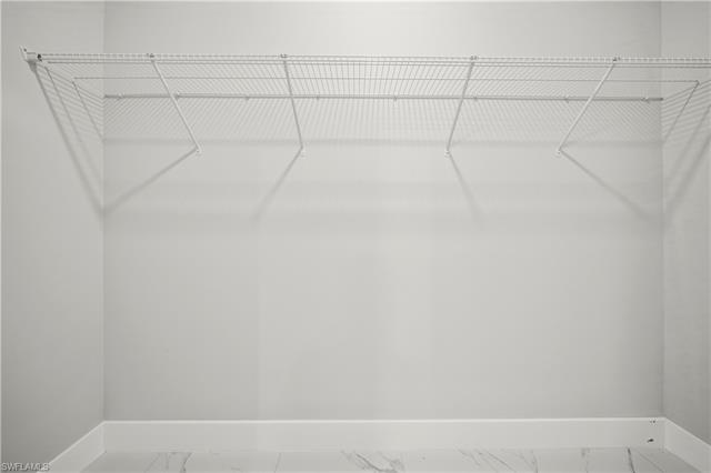 Walk in closet featuring marble finish floor