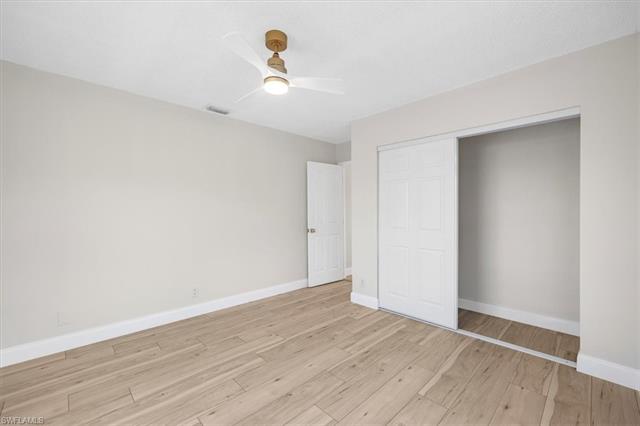 Unfurnished bedroom featuring baseboards, visible vents, a closet, and light wood finished floors