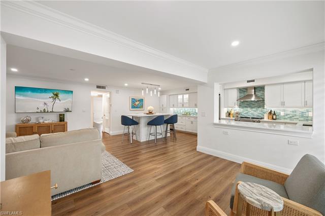 Living room with visible vents, baseboards, ornamental molding, recessed lighting, and light wood-style floors