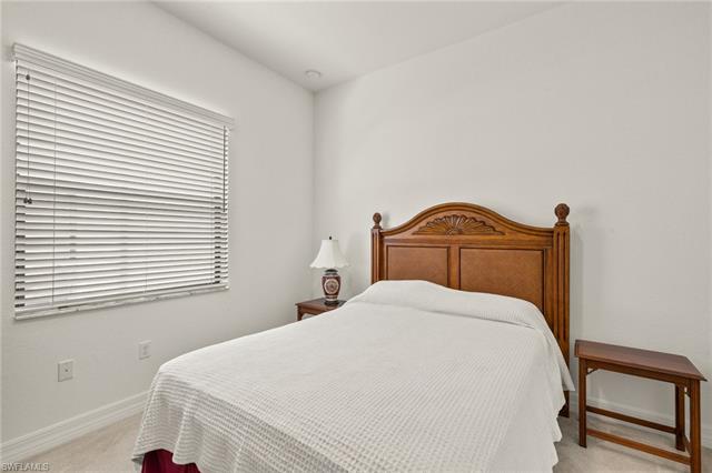 Bedroom featuring light carpet and baseboards