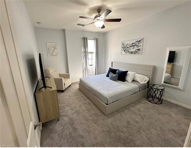 Bedroom featuring baseboards, visible vents, ceiling fan, and carpet flooring