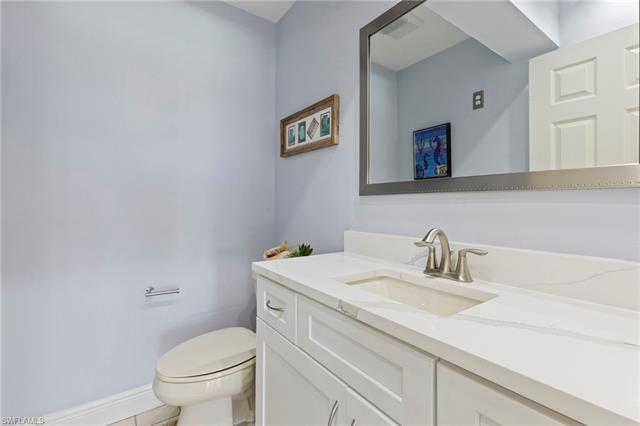 Bathroom featuring baseboards, visible vents, toilet, and vanity