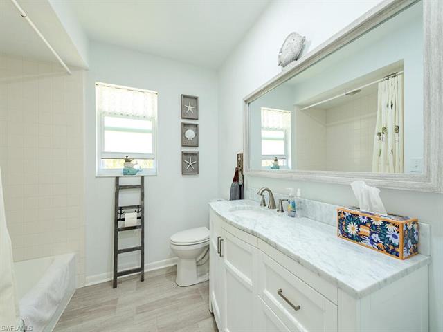 Full bath featuring baseboards, toilet, vanity, and shower / bathtub combination with curtain