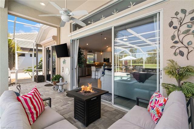 View of patio with a ceiling fan, an outdoor living space with a fire pit, and a lanai