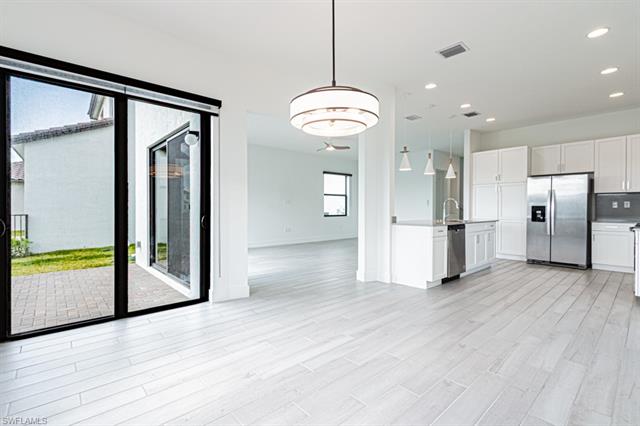 Kitchen featuring open floor plan, white cabinets, appliances with stainless steel finishes, and visible vents