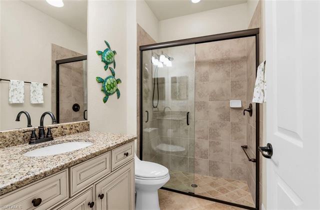 Full bath with vanity, toilet, tile patterned floors, and a shower stall