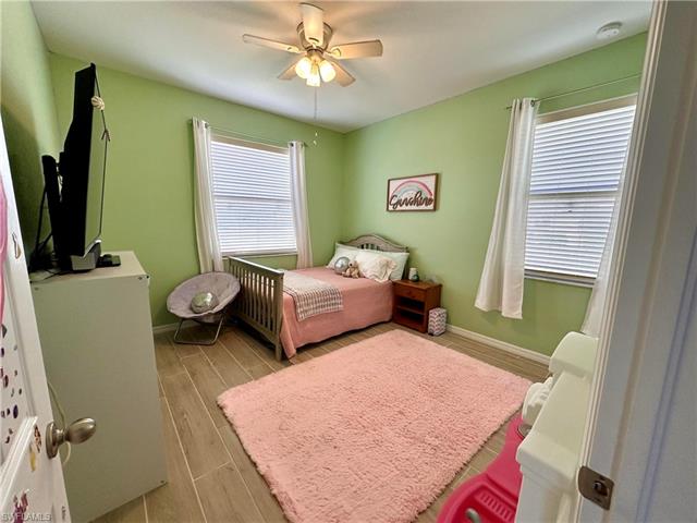 Bedroom with baseboards, a ceiling fan, and wood finish floors