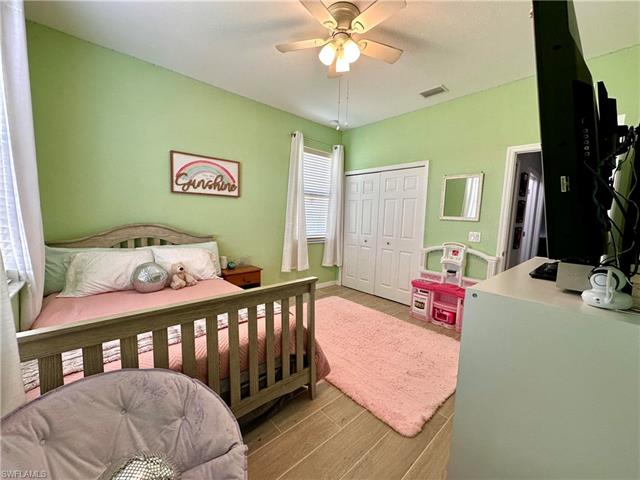 Bedroom featuring a ceiling fan, a closet, light wood-style floors, and visible vents